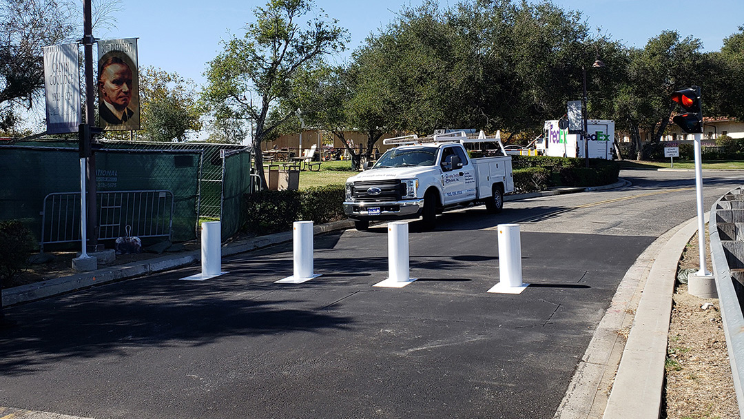 Retractable crash-rated bollards raised to block vehicle access on a roadway