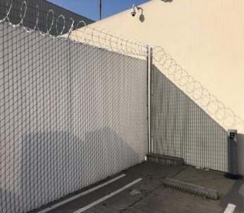 Commercial chain-link security fencing with barbed-wire perimeter protection