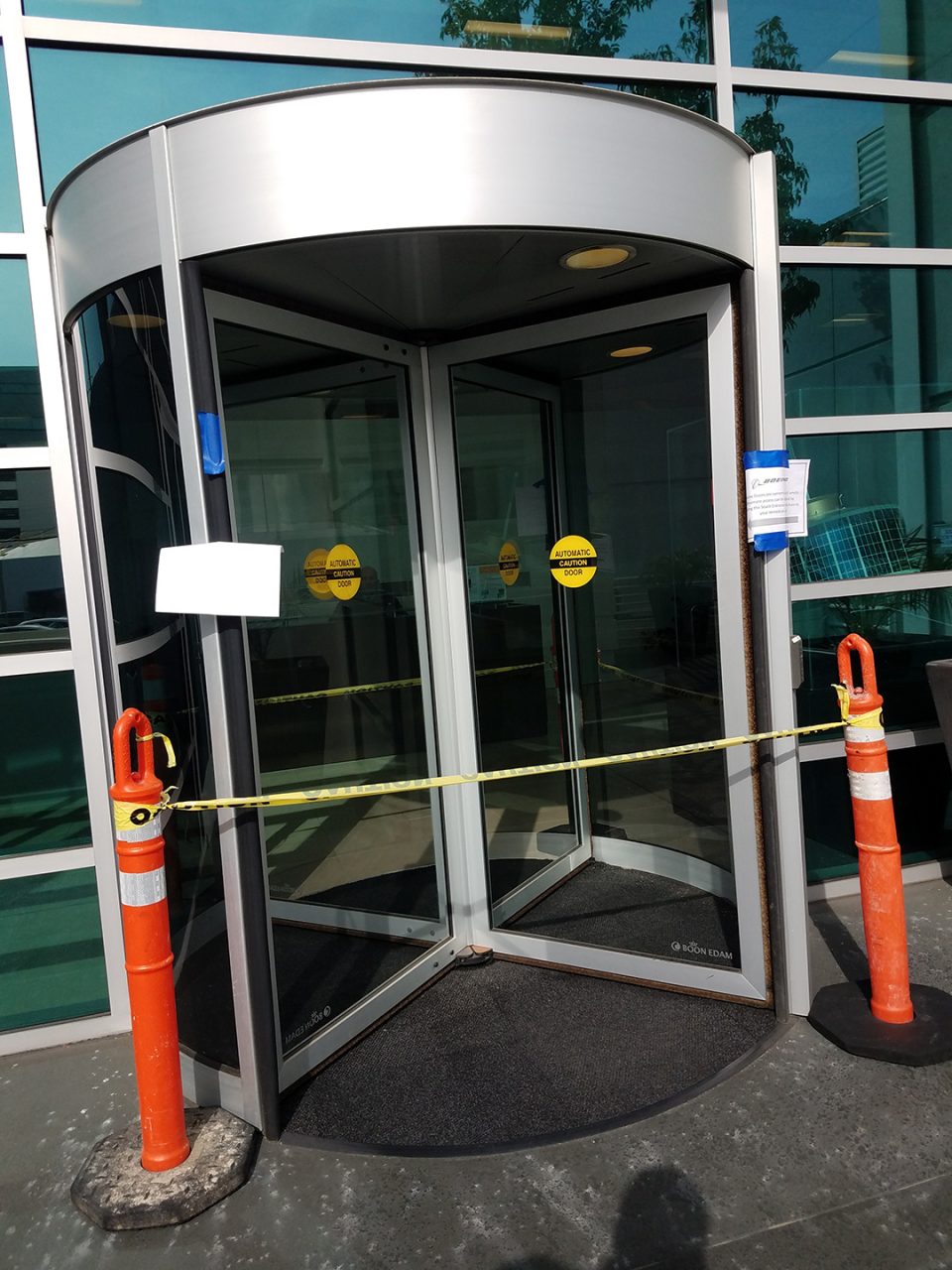 Monitored revolving door entry at a public-facing facility with glass curtain wall