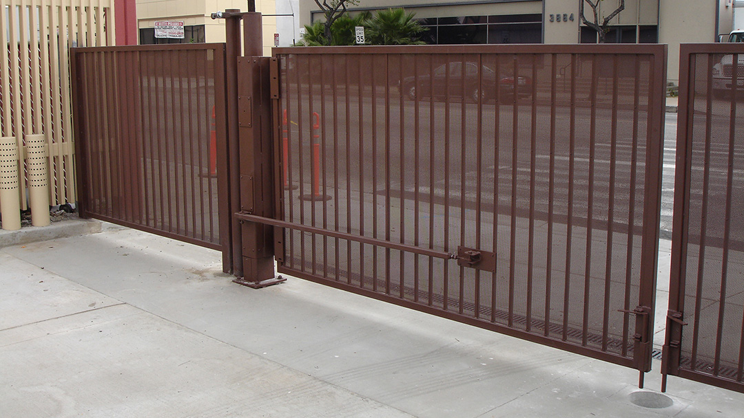 Steel vehicle swing gate controlling access at a street-facing commercial entrance